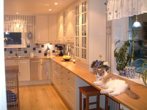 Vitt kök med randiga gardiner