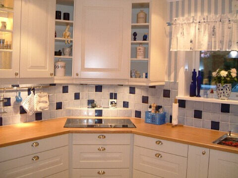 Kök med blått kakelmönster och vita skåp