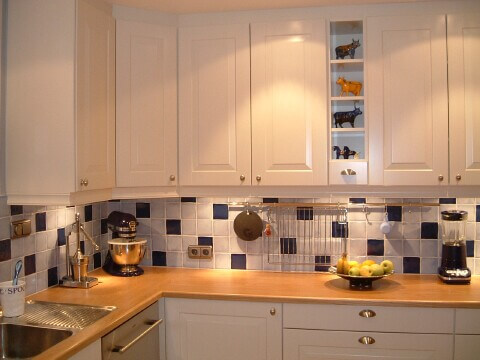 Vitt kök med kakel och frukt på bänken